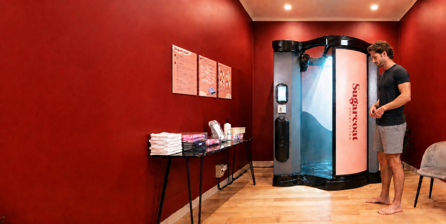 Red modern salon interior with a person entering a futuristic tanning booth, white towel shelf, and minimalist furniture.