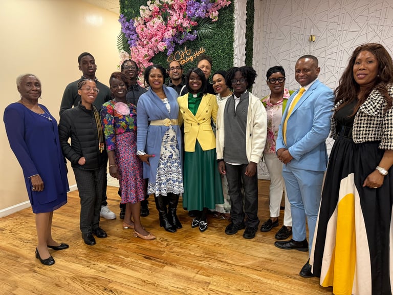 Group of people posing together in front of a floral backdrop at an indoor event