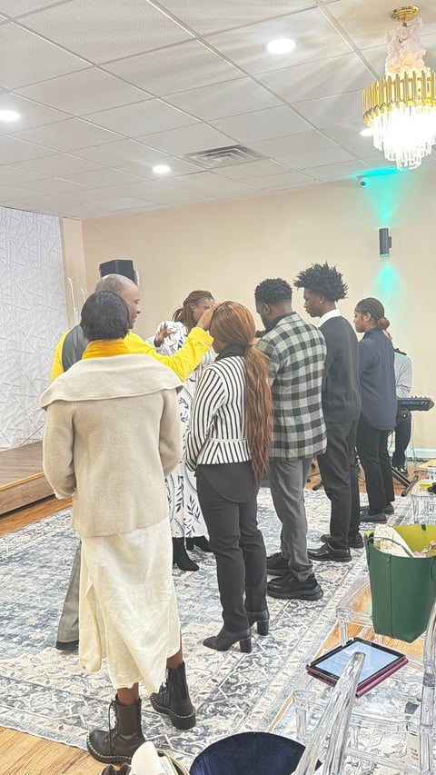 Group of people gathered in an elegant room with chandelier, discussing or greeting each other in business casual attire