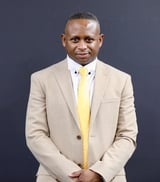 Mr. Omar Jackson, leader of the BOL Kingdom Men Arise Fellowship, in a professional headshot wearing a beige blazer and yellow tie