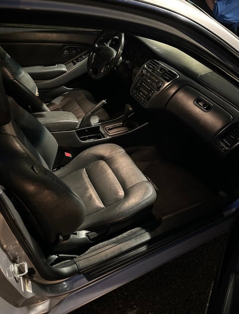 Interior view of a car with leather seats, steering wheel, dashboard, and center console