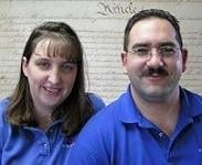 Two people wearing blue shirts posing together for a portrait photo