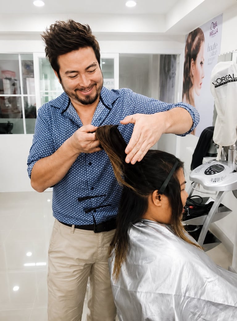 Male hairstylist working on clients hair in a modern salon setting
