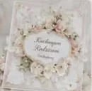 Beige floral greeting card with cream flowers and green foliage surrounding handwritten text