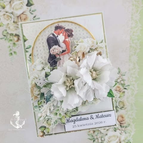 Handmade wedding card featuring couple photo in gold frame surrounded by white and cream flowers and greenery with names and date