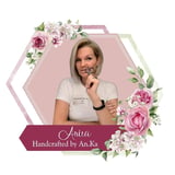 Portrait of Anita in a white t-shirt within a floral-decorated hexagonal frame with pink roses and green leaves, text reads Handcrafted by An.Ka
