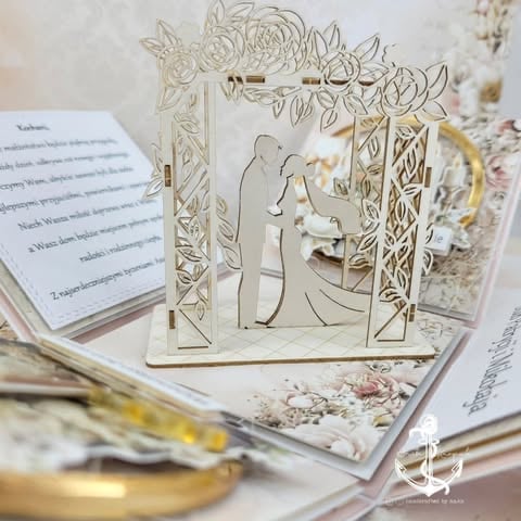 Laser-cut wooden wedding arch with bride and groom silhouettes surrounded by floral frame, displayed with invitation cards and decorative papers