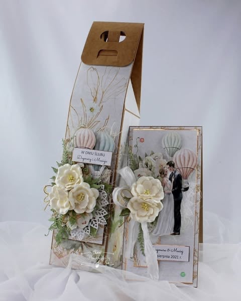 Handmade wedding card with cream roses, hot air balloon designs, and a kraft paper envelope featuring a sad face cutout.