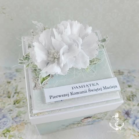 White floral keepsake box with delicate paper flower, lace, and Polish text commemorating First Holy Communion.