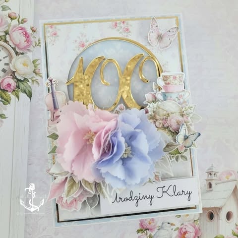 Handmade greeting card with gold number 60, pink and blue flowers, decorative butterfly, and Drodzinny Klary text on white background