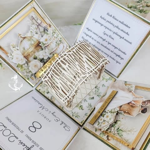 Elegant wedding stationery set with gold-trimmed cards, white floral designs, decorative feathers, and wooden pen displayed on white background