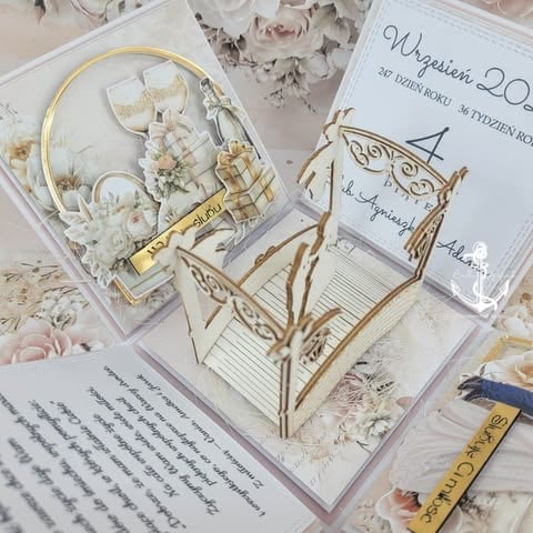 Elegant wedding invitation display with gold decorative items, dried flowers, and stationery arranged on a floral patterned surface