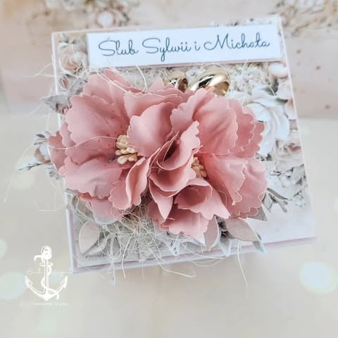 Handmade wedding card with pink fabric flower, dried grasses, personalized name banner, and anchor detail.