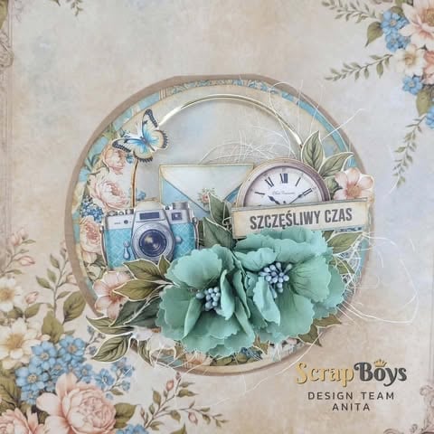 Decorative scrapbook layout featuring a vintage clock, blue camera, floral elements, and green fabric flowers on patterned background