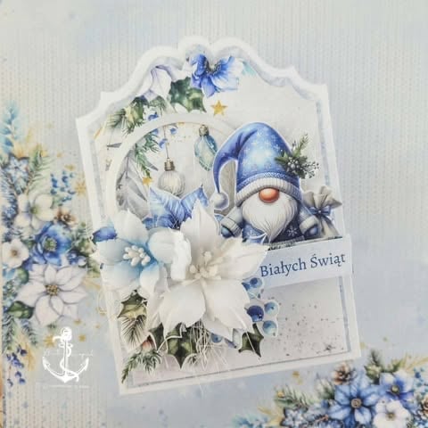 Handmade Christmas card featuring blue gnome, white flowers, and Bialych Swiat text on cream background