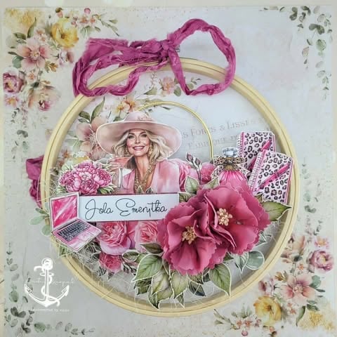 Decorative scrapbook page with gold circular frame, pink floral embellishments, woman in hat, and handwritten text label