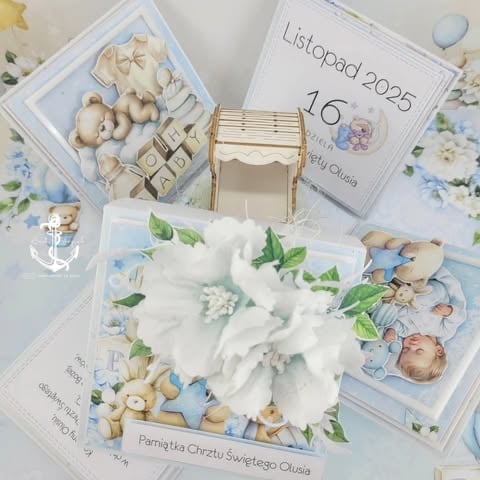 Christening exploding box for Oliwia with calendar Listopad 2025, white peonies, sleeping baby, 'Pamiątka Chrztu Świętego Oliwia' text, and teddy bear in blue and cream tones