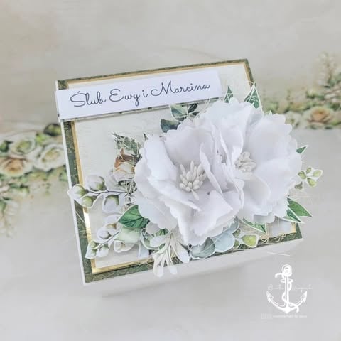 Handmade greeting card with white flower and green foliage decorated on a kraft frame with personalized text label