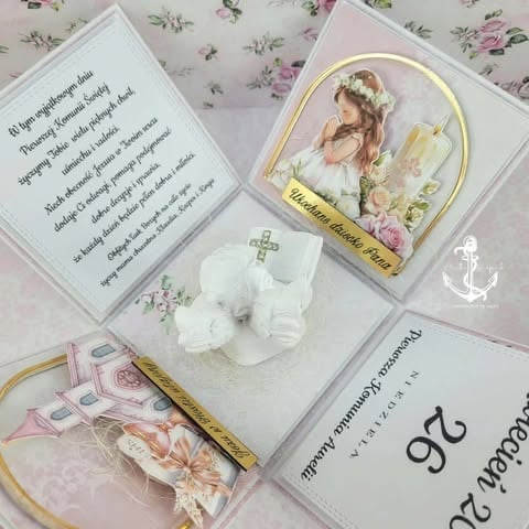 Religious keepsake set with prayer cards, ornaments, and decorative items featuring a young girl in communion dress arranged on floral patterned background.