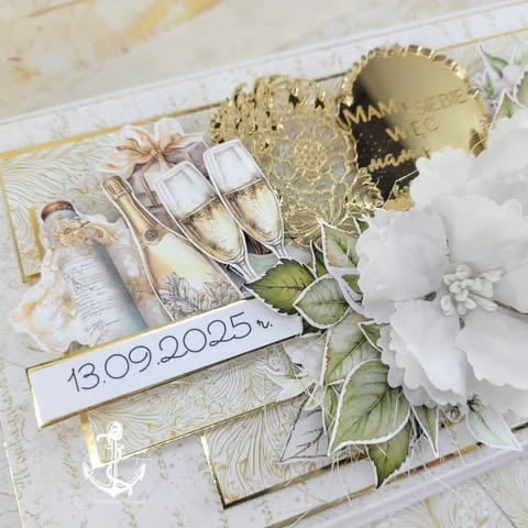Elegant wedding card with gold accents, champagne glasses, white flowers, and date tag 13.09.2025.