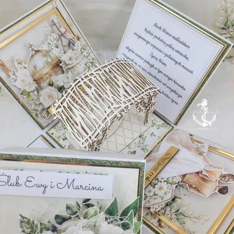 Overhead view of elegant wedding stationery and decor including invitations, a decorative basket, floral arrangements, and gold accents with nautical details