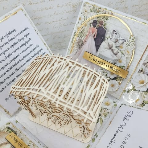 Decorative white wicker basket with wedding photo, gold ribbon, handwritten letters, and dried flowers on ivory background
