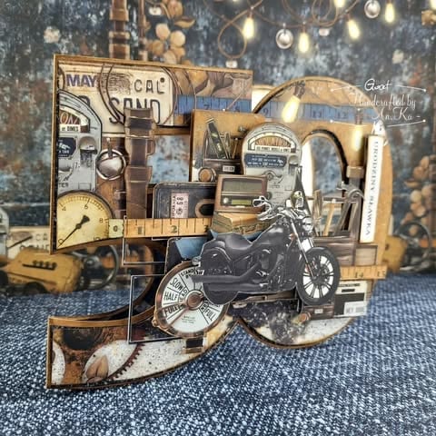 Steampunk-style mixed media collage shaped as 50 with vintage motorcycle, gears, gauges, maps, and industrial elements on textured blue background