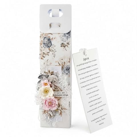 Decorative rectangular box with floral pattern featuring white, pink, and yellow flowers, with information card attached.
