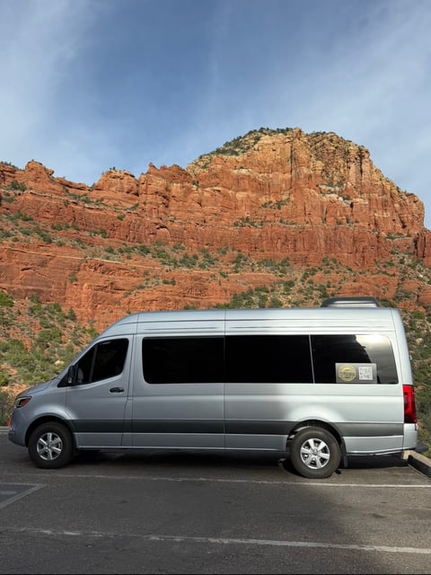 Touch of Excellence silver sprinter van parked at Sedona red rocks