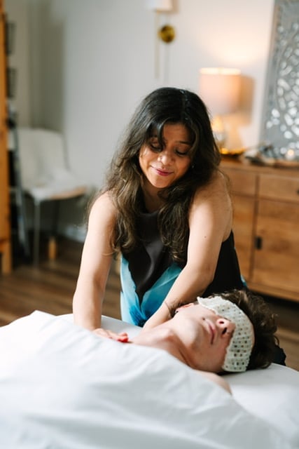 Cat performing a scalp and head massage on a seated client