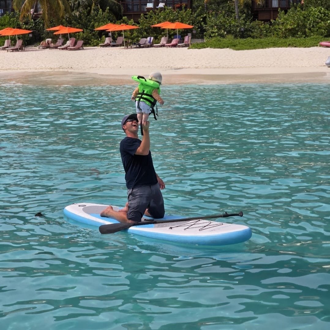 Good Ol' Days — person on paddleboard with child in turquoise water