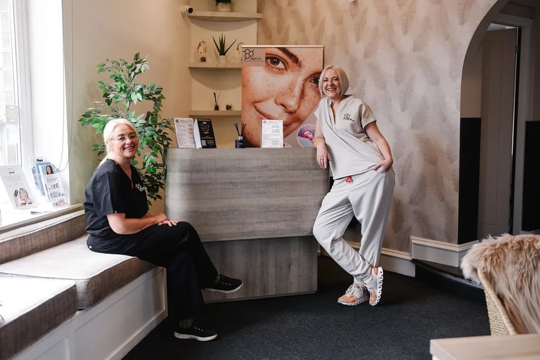 Professional clinic reception area with patient sitting on bench and receptionist standing at desk with large portrait on wall