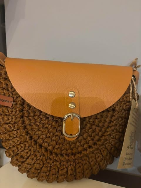 Brązowa pikowana torebka crossbody Oreo z pomarańczową skórzaną klapką i srebrnym okrągłym zapięciem.