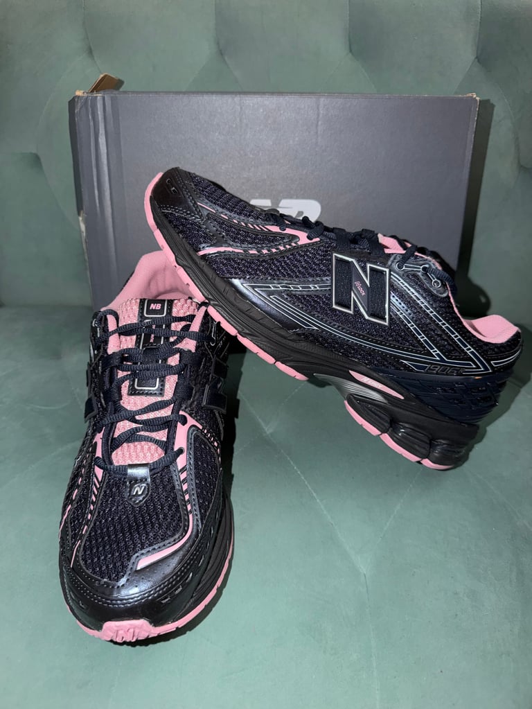New Balance 1906R white sneakers with black stripes on a blue box