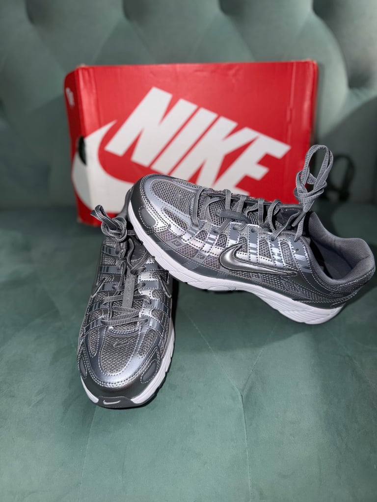 Nike P-6000 Metallic Cool Grey (GS) white sneakers with black stripes on a blue box