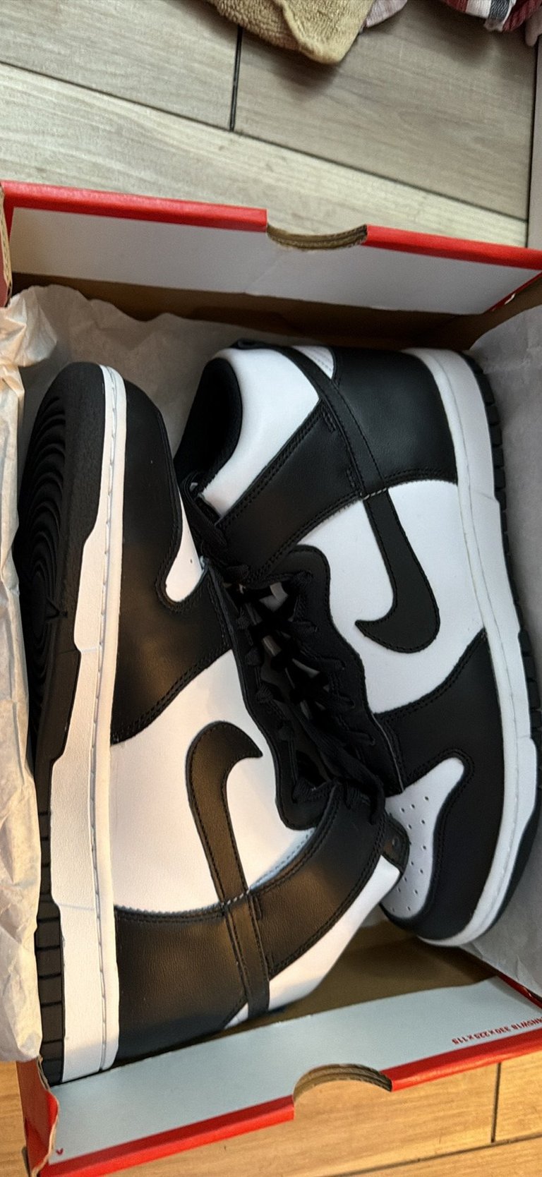 Nike Dunk High Retro white sneakers with black stripes on a blue box