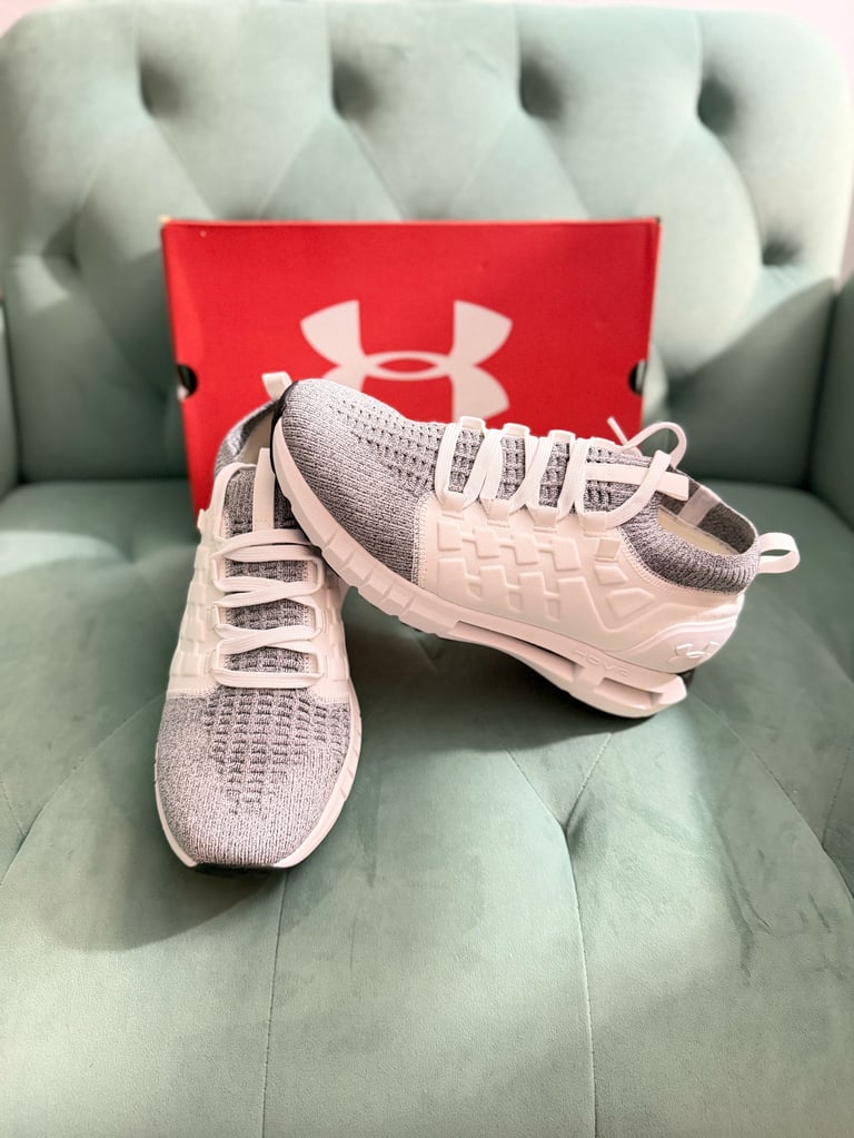Under Armour HOVR Phantom white sneakers with black stripes on a blue box