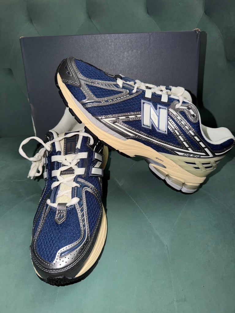 New Balance 1906R Navy Blue white sneakers with black stripes on a blue box