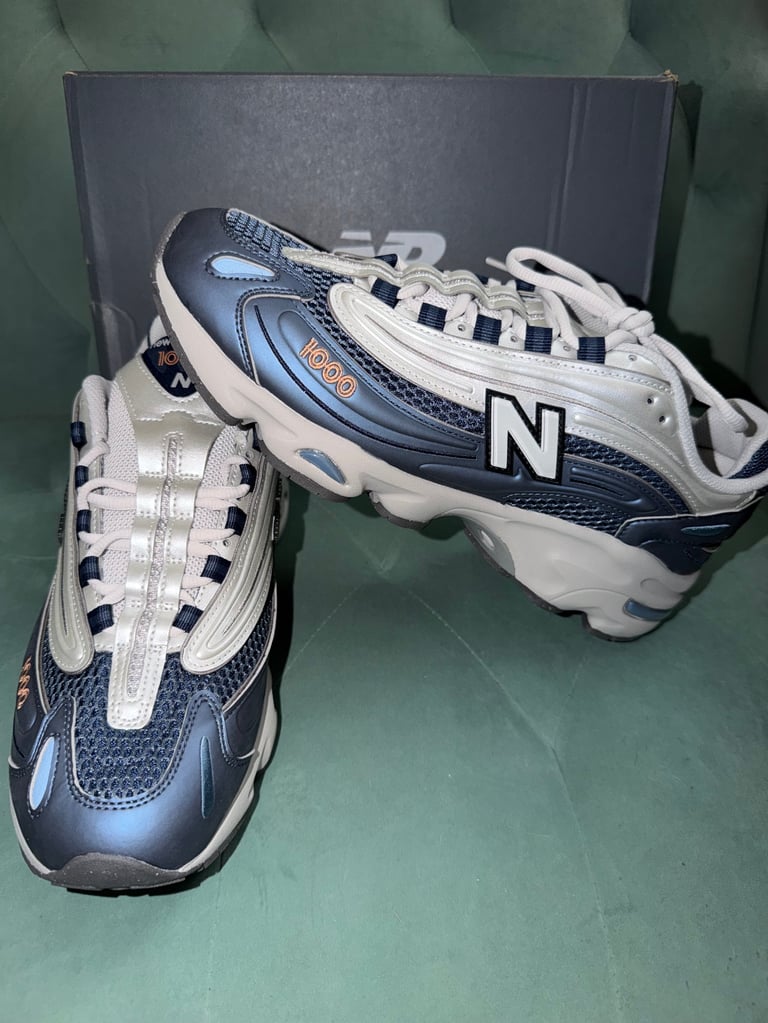 New Balance 1000 Blue Grey white sneakers with black stripes on a blue box